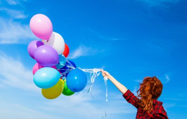 çok renkli balonlarla ekose elbiseli kız