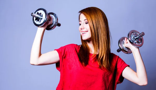 Chica en camiseta roja con mancuernas de metal — Foto de Stock