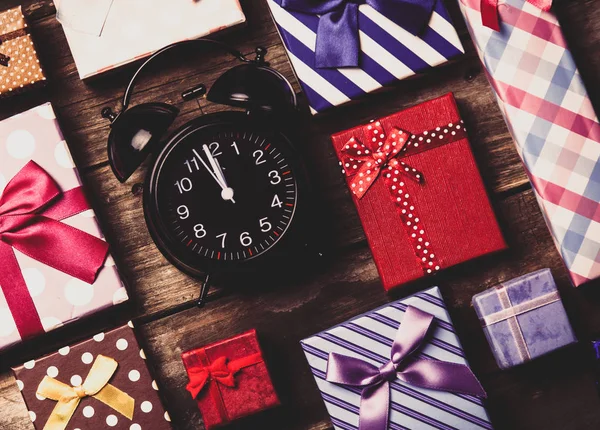 Kolorowe prezenty i zegar na stole — Zdjęcie stockowe