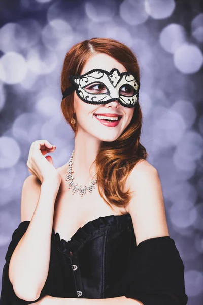 Kvinna i masken och svart klänning — Stockfoto
