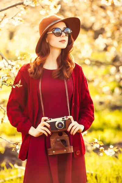 Kvinna med kameran i blossom apple tree garden — Stockfoto