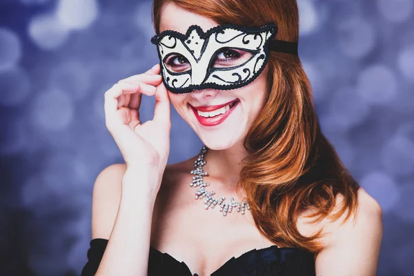 Kvinna i masken och svart klänning — Stockfoto