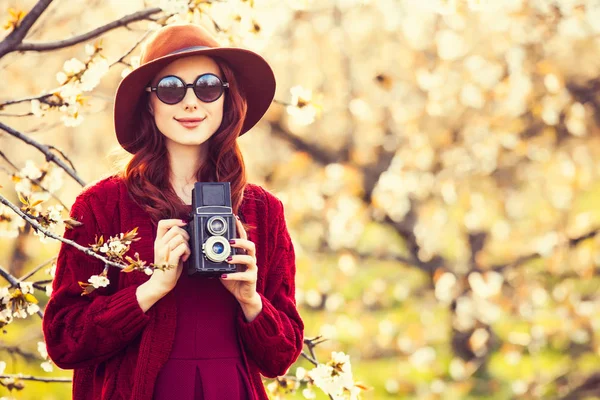 Vrouw met camera in bloesem apple tree tuin — Stockfoto