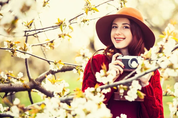 Vrouwen in rode trui en muts met camera — Stockfoto