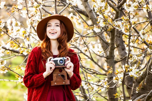 Kadın kırmızı kazak ve kamera ile şapka — Stok fotoğraf