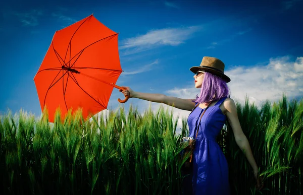 Jonge vrouw met camera en paraplu — Stockfoto