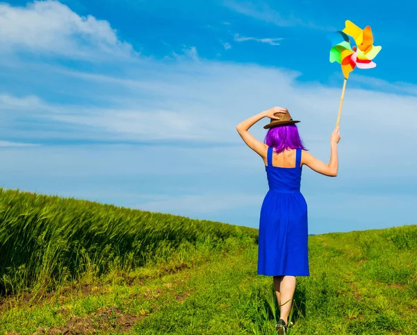 Junge Frau mit Windrad nahe Feld — Stockfoto