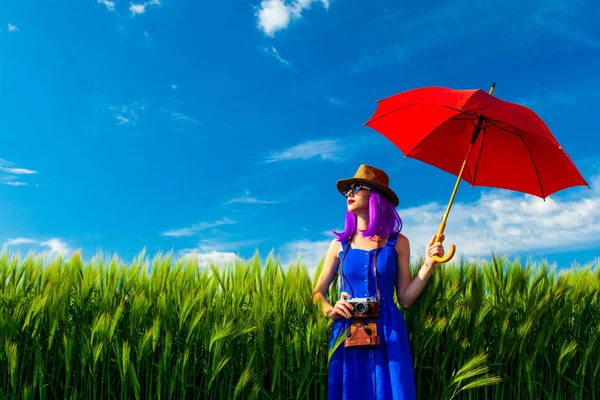 Young woman with camera and umbrella — Stock Photo, Image