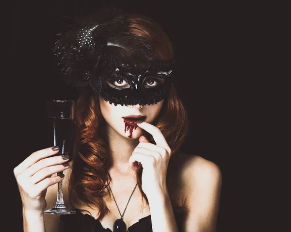 Rossa donna vampiro in maschera con vetro di sangue . — Foto Stock