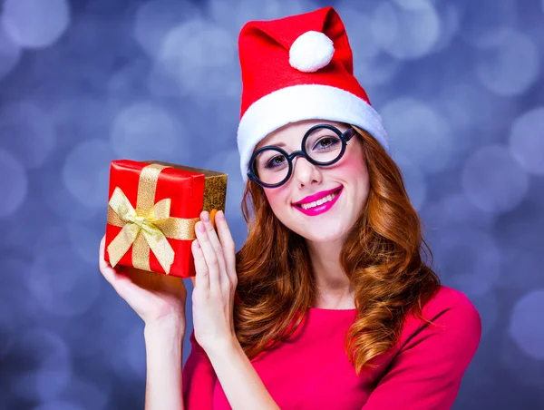 Rödhårig tjej i jul hatt med gåva. — Stockfoto