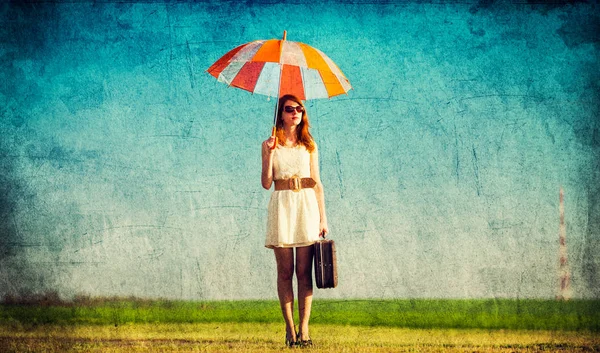 Redhead enchantress with umbrella and suitcase — Stock Photo, Image