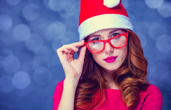 Menina no chapéu de Natal e óculos no fundo cinza — Fotografia de Stock