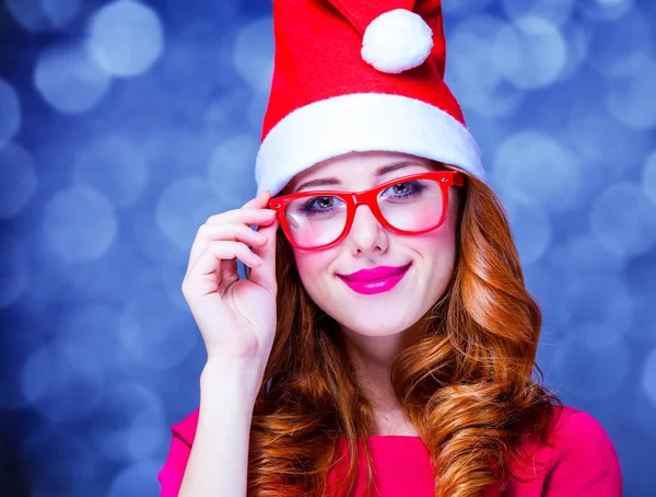Menina no chapéu de Natal e óculos no fundo cinza — Fotografia de Stock