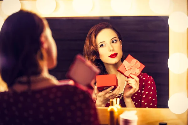 Portret van een mooie vrouw als toepassing van make-up in de buurt van een spiegel — Stockfoto