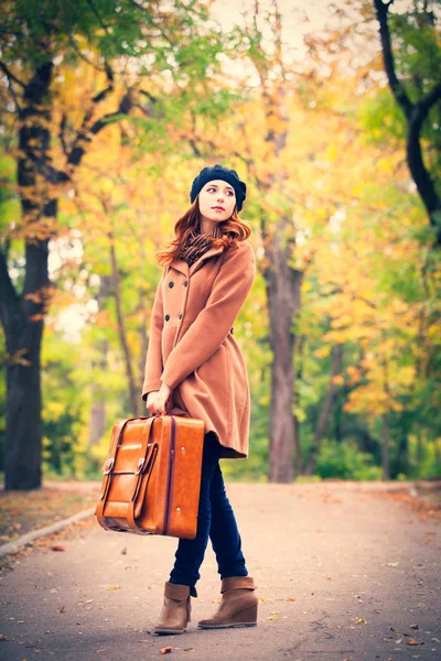 Рыжая девушка с чемоданом — стоковое фото