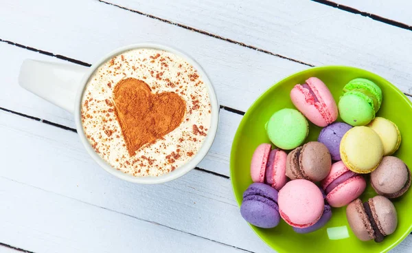 Cappuccino com símbolo de forma de coração e macaron — Fotografia de Stock