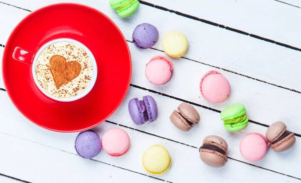 Cappuccino with heart shape symbol and macaron — Stock Photo, Image