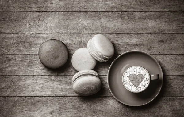 Tasse und Macarons auf Holzgrund — Stockfoto