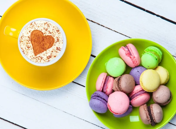 Cappuccino with heart shape symbol and macaron — Stock Photo, Image