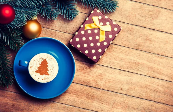 Cappuccino and gift with pine branch — Stock Photo, Image