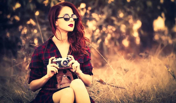 Dziewczyna w kratę sukienka retro camera i okulary przeciwsłoneczne — Zdjęcie stockowe