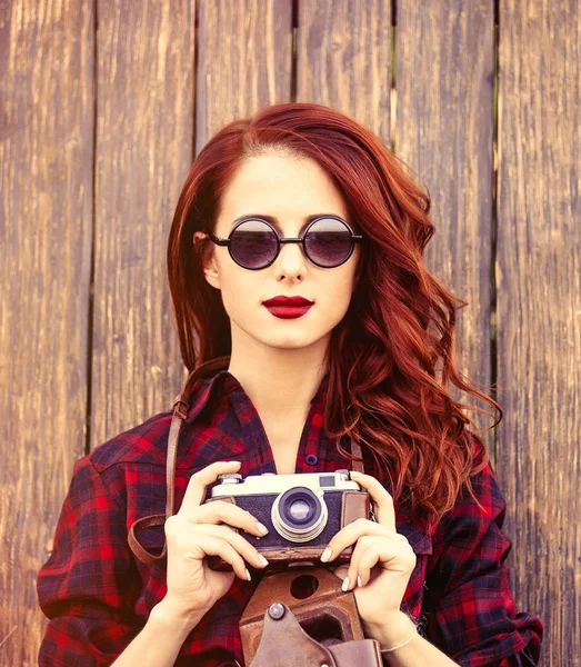 Meisje in geruite jurk met camera en zonnebril — Stockfoto