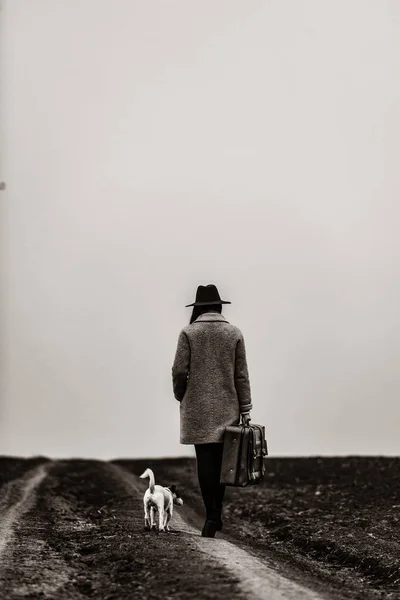 Portrait of young woman with suitcase and dog — Stock Photo, Image