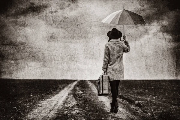 Porträt einer jungen Frau mit Regenschirm und Koffer — Stockfoto