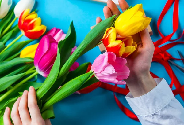 Les Mains Féminines Tiennent Flux Tulipes Sur Fond Bleu — Photo