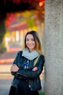 Kırmızı üzüm sokakta column yakınındaki ceketli genç kız. Sonbahar sezonu zaman