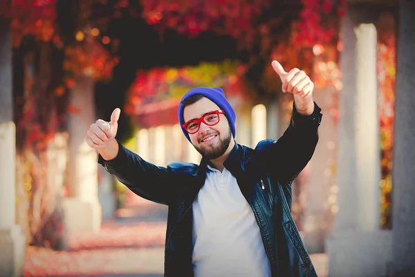 Young White Guy Glasses Hat Park Show Sign Yellow Trees — Stock Photo, Image