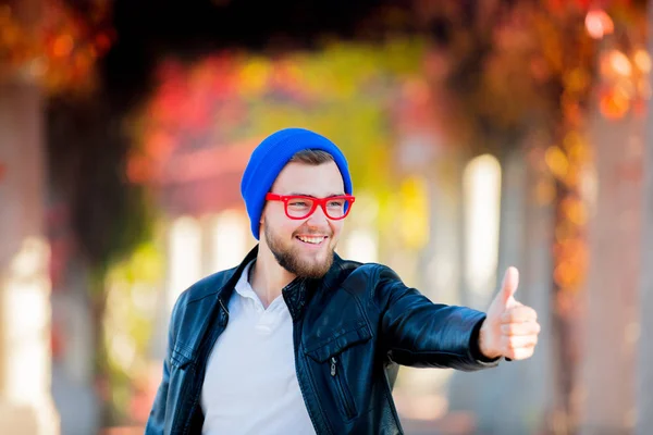 Young White Guy Glasses Hat Park Show Sign Yellow Trees — Stock Photo, Image