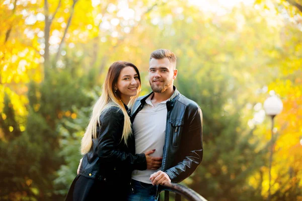 年轻风格的白色夫妇摆在一座桥在公园与黄色的颜色树背景 秋季季节时间 — 图库照片