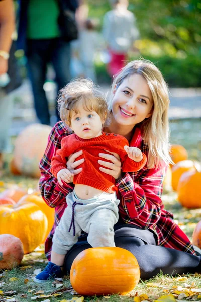 Madre Joven Con Hijo Una Ley Con Calabazas Tiempo Temporada —  Fotos de Stock