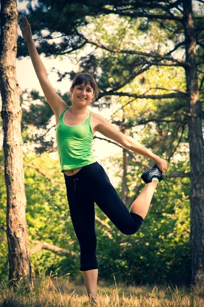 Młoda piękna dziewczyna robi ćwiczenia fizyczne w parku. — Zdjęcie stockowe