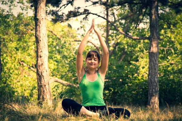 Young beautiful girl doing physical exercises in a park. — Stock Photo, Image