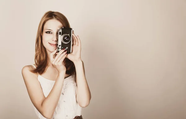 Chica en un vestido blanco sosteniendo una cámara clásica — Foto de Stock