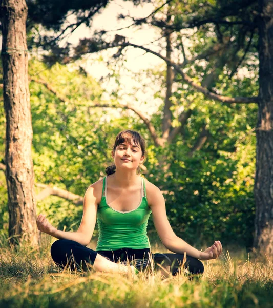 Young beautiful girl doing physical exercises in a park. — Stock Photo, Image