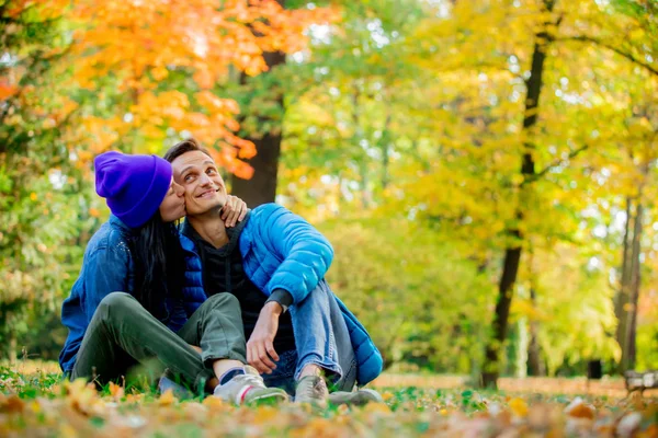 Pareja Joven Sentada Suelo Besándose Parque Otoñal —  Fotos de Stock