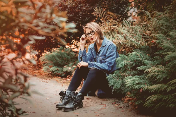 Denim Ceket Gözlük Park Zeminde Oturan Genç Kadın Sonbahar Sezonu — Stok fotoğraf