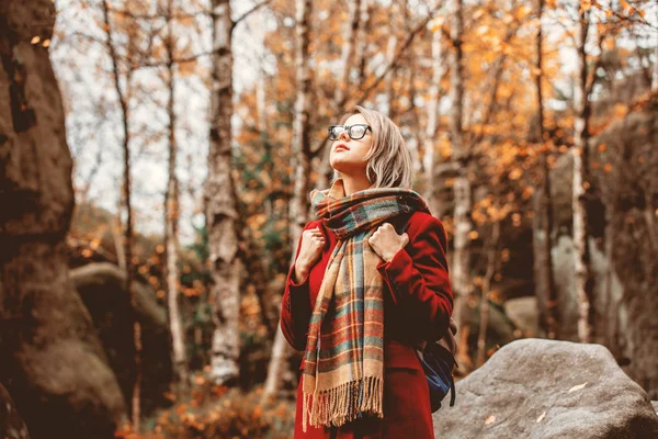 スカーフと岩と森のコートに若い女性は 山の秋シーズンの時間 — ストック写真