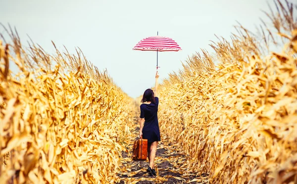 Jonge vrouw met koffer en paraplu — Stockfoto
