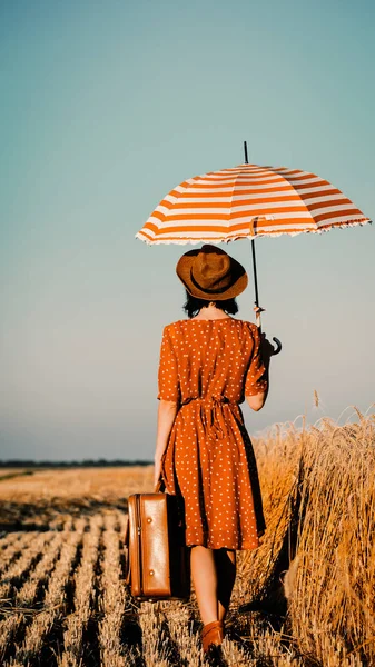 Młoda kobieta z parasolem i walizka — Zdjęcie stockowe