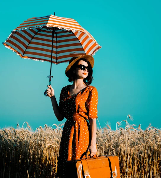 Young woman with umbrella and suitcase — Stock Photo, Image