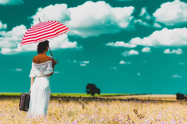 スーツケースと傘を持つ若い女性 — ストック写真