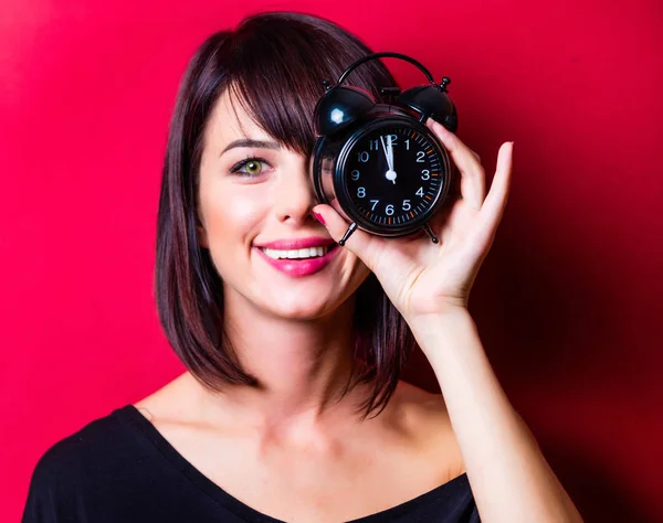 Jonge vrouw met wekker — Stockfoto