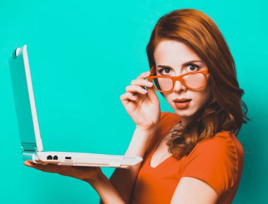 Kızıl saçlı kız ile mavi arka plan üstünde laptop.