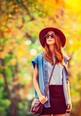 Kızıl saçlı kız güneş gözlüğü ve şapka sonbahar Park.