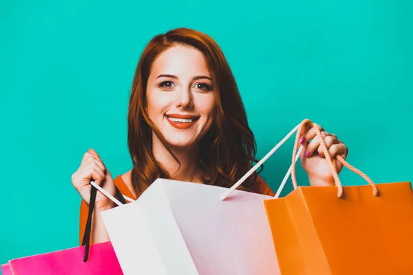 Ragazza Rossa Con Borse Della Spesa Sfondo Blu — Foto Stock