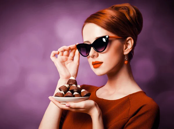 红色的妇女与糖果在紫罗兰色背景 — 图库照片
